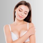 Woman in white bra with natural-looking breast enhancement.